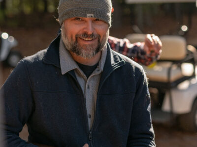 Man with beard and beanie smiling at the camera