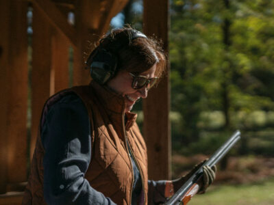 Woman in shooting blind holding a rifle